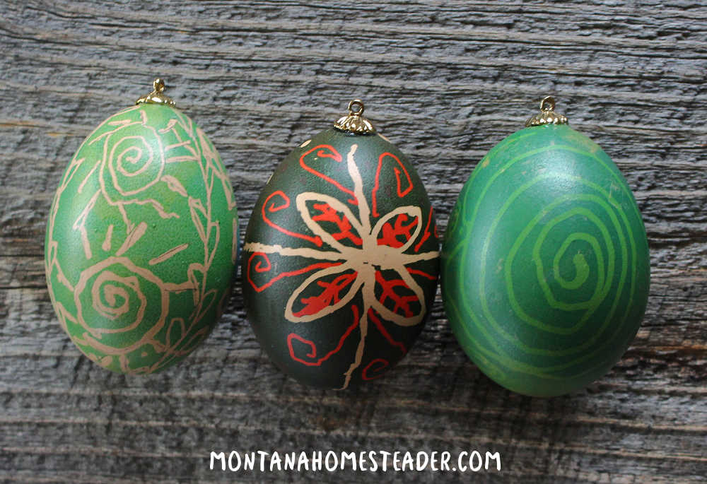 How to decorate blown eggs with Pysanky how to do Pysanky eggs using wax resist and dye green egg with wax resist sunshine and flowers Pysanky egg with green red and white lines dots flowers and green egg with Pysanky wax resist spiral swirl in lighter color