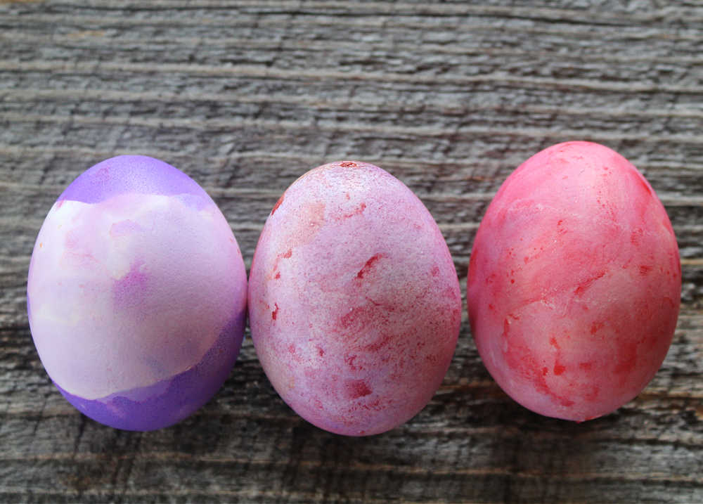 How to dye blown eggs with homemade food coloring and vinegar dye dip dyed egg in various shades of purple egg with swirled pink purple and red dye colors and Easter egg with various shades of pink and red dye swirled
